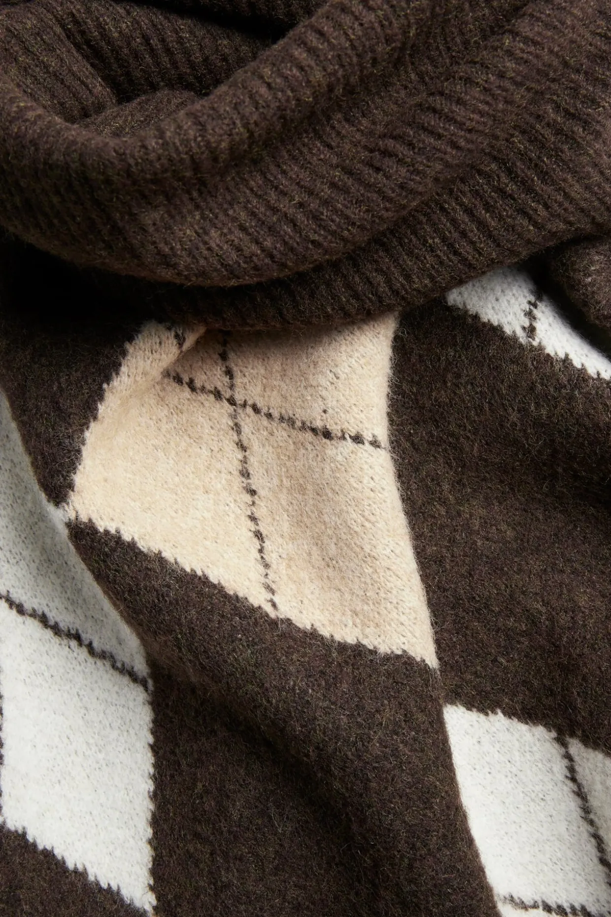 Stickad poncho med polokrage och rutmönster