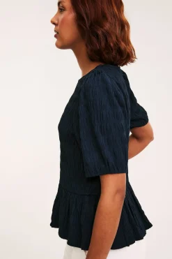 Strukturerad topp med peplum och kort ärm