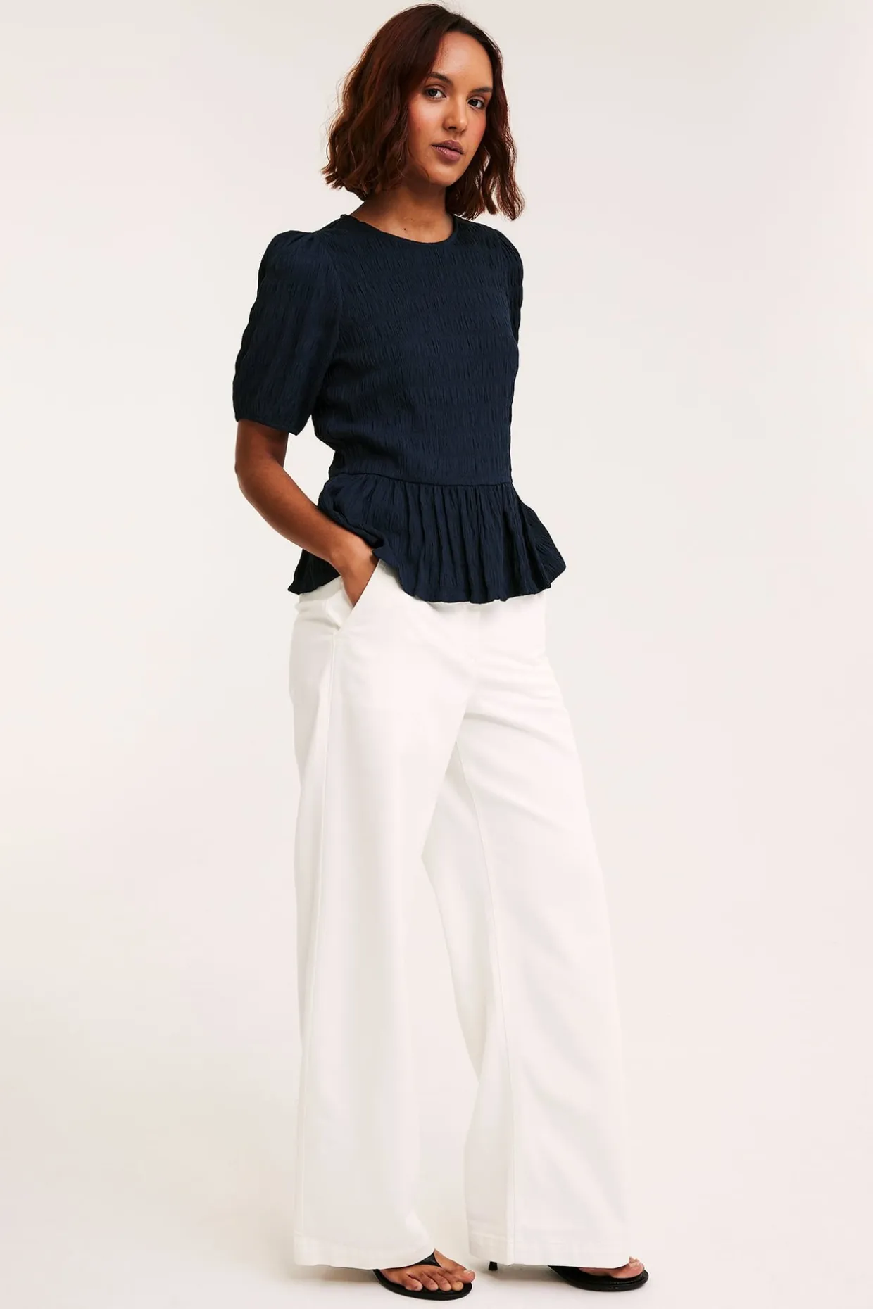 Strukturerad topp med peplum och kort ärm